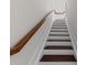 Staircase with wood steps and white risers, featuring a wood handrail at 256 William Drummond Way, Raleigh, NC 27604