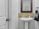 Powder room features a pedestal sink, decorative mirror, attractive wall accents, and modern fixtures at 2801 Dearborn Dr # A, Durham, NC 27704