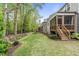 Spacious backyard with a screened-in porch, lush lawn, mature trees, and well-maintained landscaping at 2812 Lemnos Dr, Apex, NC 27502