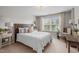 Bright bedroom featuring a large window with natural light, a wood-framed bed, and neutral décor at 2812 Lemnos Dr, Apex, NC 27502