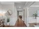 Hallway with wood floors, wainscoting, decorative mirror, and views into living spaces at 2812 Lemnos Dr, Apex, NC 27502