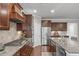 Features of a modern kitchen include stainless steel appliances, granite counters, tile backsplash and rich wood cabinetry at 2812 Lemnos Dr, Apex, NC 27502