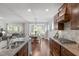 The kitchen flows into the dining area, featuring modern stainless steel appliances, wood floors, and granite countertops at 2812 Lemnos Dr, Apex, NC 27502