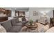 Living room open to the kitchen features hardwood floors, modern furnishings, and a view of the front yard at 2812 Lemnos Dr, Apex, NC 27502
