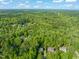 Extensive aerial view of the home, situated within a dense forest of mature trees, showcasing its secluded setting at 314 Hogan Woods Cir, Chapel Hill, NC 27516
