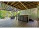 Covered backyard patio includes a hot tub and cozy furniture for outdoor relaxation at 314 Hogan Woods Cir, Chapel Hill, NC 27516