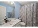 Powder blue bathroom with shower-tub combination and patterned curtain next to sink and vanity at 314 Hogan Woods Cir, Chapel Hill, NC 27516
