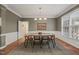 Elegant dining room with hardwood floors, wainscoting, a modern chandelier, and a large window at 314 Hogan Woods Cir, Chapel Hill, NC 27516
