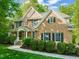 Two-story brick home featuring classic architecture, trimmed shrubbery, and mature trees at 314 Hogan Woods Cir, Chapel Hill, NC 27516
