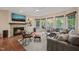 Cozy living room featuring a stone fireplace, hardwood floors, and a comfortable seating area with large windows at 314 Hogan Woods Cir, Chapel Hill, NC 27516