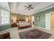 Spacious bedroom with tray ceilings, large windows, a four-poster bed, and an ensuite bathroom at 314 Hogan Woods Cir, Chapel Hill, NC 27516