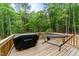 Backyard deck featuring a grill and a comfortable hammock, perfect for outdoor relaxation at 318 Natchez Trace, Fuquay Varina, NC 27526