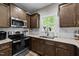 Well-lit kitchen with stainless steel appliances, granite countertops, and tile backsplash at 318 Natchez Trace, Fuquay Varina, NC 27526