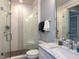 Bathroom with glass enclosed shower, white marble countertop and a large mirror at 3416 Edgemont Dr, Raleigh, NC 27612