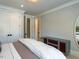 Neutral bedroom featuring a large bed with white bedding, and doorway to the bathroom at 3416 Edgemont Dr, Raleigh, NC 27612