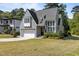 Charming gray home featuring a manicured lawn, stylish architectural details, and a welcoming two-car garage at 3416 Edgemont Dr, Raleigh, NC 27612