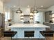 Elegant kitchen with a large center island, pendant lighting, and stainless steel appliances at 3416 Edgemont Dr, Raleigh, NC 27612