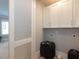 Laundry area with white cabinets, washer/dryer hookups and access to living area at 3416 Edgemont Dr, Raleigh, NC 27612