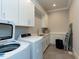 Laundry room with front loading washer/dryer, cabinetry, and countertop space at 3416 Edgemont Dr, Raleigh, NC 27612