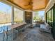 Covered patio with stone floors, ceiling fan, outdoor fireplace, and lounge seating overlooking the backyard at 3416 Edgemont Dr, Raleigh, NC 27612