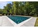 Inviting backyard pool with a tanning ledge and gentle water features, set in a lush, green landscape at 3416 Edgemont Dr, Raleigh, NC 27612