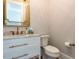 Elegant powder room with marble countertop, gold fixtures, and a decorative mirror at 3416 Edgemont Dr, Raleigh, NC 27612
