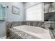 Inviting bathroom with a jacuzzi tub, granite countertop, and sunny window at 3428 Hardwood Dr, Apex, NC 27539