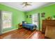 Bright bedroom with green walls, hardwood floors, and natural light from two windows at 3428 Hardwood Dr, Apex, NC 27539