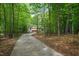 Long driveway leading to a charming home surrounded by trees and nature at 3428 Hardwood Dr, Apex, NC 27539