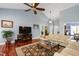 Bright living room with hardwood floors, a ceiling fan, and a traditional rug at 3428 Hardwood Dr, Apex, NC 27539