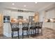 Modern kitchen featuring white cabinets, granite countertops, stainless steel appliances, and stylish bar stools at 37 Blue Spruce Cir, Clayton, NC 27527