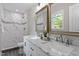 Bathroom featuring double vanity with marble countertop and a stylish mirror at 3713 Arrowwood Dr, Raleigh, NC 27604