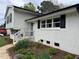 Charming front entrance with white brick, black shutters, and a colorful flower bed at 3713 Arrowwood Dr, Raleigh, NC 27604