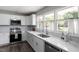 Bright kitchen with white cabinets, stainless steel appliances, marble countertops, and large windows at 3713 Arrowwood Dr, Raleigh, NC 27604