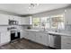 Bright kitchen with white cabinets, stainless steel appliances, marble countertops, and natural light at 3713 Arrowwood Dr, Raleigh, NC 27604