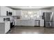 Spacious open kitchen with stainless steel appliances, white cabinetry, and hardwood flooring at 3713 Arrowwood Dr, Raleigh, NC 27604