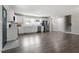 Bright, open kitchen featuring white cabinetry, stainless steel appliances, and expansive gray hardwood flooring at 3713 Arrowwood Dr, Raleigh, NC 27604