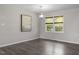 Bright room featuring hardwood floors, a modern light fixture, and natural light through the large windows at 3713 Arrowwood Dr, Raleigh, NC 27604