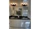 Bathroom features dual sinks, black granite countertops, and a large mirror at 409 Parkside Cir, Chapel Hill, NC 27516