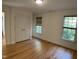 A spacious bedroom with hardwood floors, two windows, and a closet with double doors at 409 Parkside Cir, Chapel Hill, NC 27516