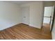 A cozy bedroom with hardwood floors, a closet, and a door that leads to the hallway and stairs at 409 Parkside Cir, Chapel Hill, NC 27516
