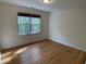A bright and airy bedroom features hardwood floors and a large window with views of the outdoors at 409 Parkside Cir, Chapel Hill, NC 27516