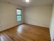 A clean and inviting bedroom with hardwood floors, a window, and neutral walls at 409 Parkside Cir, Chapel Hill, NC 27516