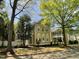 Charming two-story yellow home with white trim, mature trees, and a picket fence at 409 Parkside Cir, Chapel Hill, NC 27516