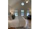 Bright and open main bedroom features a large bed and vaulted ceilings with windows at 409 Parkside Cir, Chapel Hill, NC 27516
