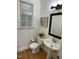 Cozy powder room featuring a pedestal sink, toilet, and window allowing plenty of natural light at 409 Parkside Cir, Chapel Hill, NC 27516