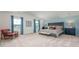 Spacious bedroom features a plush king-size bed, blue accent wall, and large windows with natural light at 487 Lochalsh Dr, Gibsonville, NC 27249