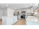 Well-lit kitchen featuring white cabinets, stainless steel appliances, light countertops, and vinyl wood-look floors at 487 Lochalsh Dr, Gibsonville, NC 27249