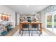 Open concept kitchen featuring white cabinets, stainless steel appliances, wooden table and bright natural light at 487 Lochalsh Dr, Gibsonville, NC 27249