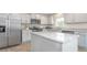Spacious kitchen with white cabinets, stainless steel appliances, white countertops, island and wood floors at 487 Lochalsh Dr, Gibsonville, NC 27249